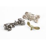 Two white metal floral brooches, one with daffodil design, the other with stylised flower head and