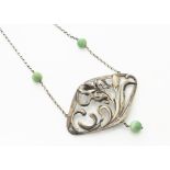 A continental white metal Art Nouveau jade set pendant necklace, the lozenge shaped pendant with