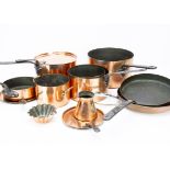 A set of four graduated copper and iron Benham and Froud cooking pans, the copper circular bowls