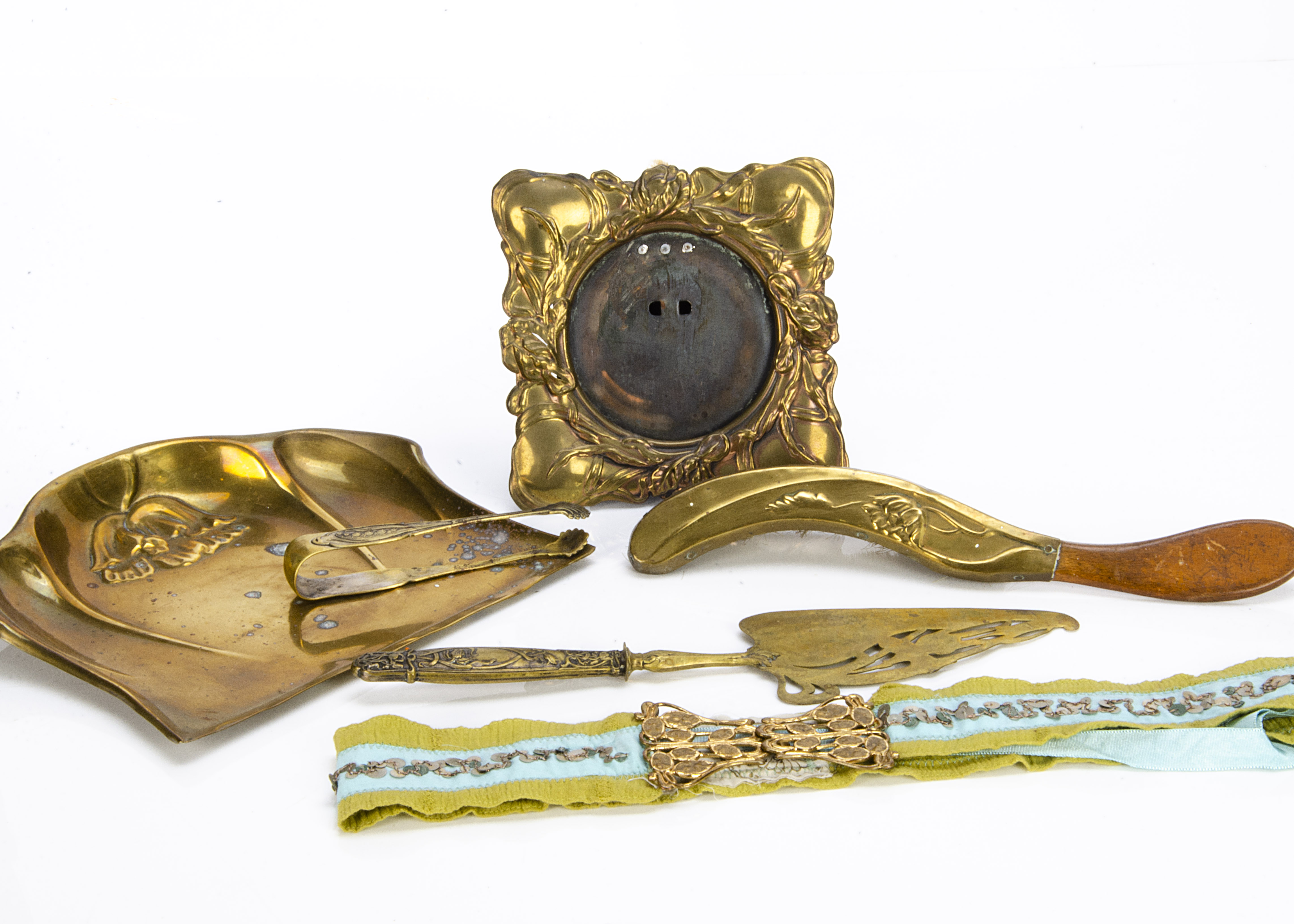 A collection of pressed brass Art Nouveau ware, including a crumb tray and brush, pressed photograph