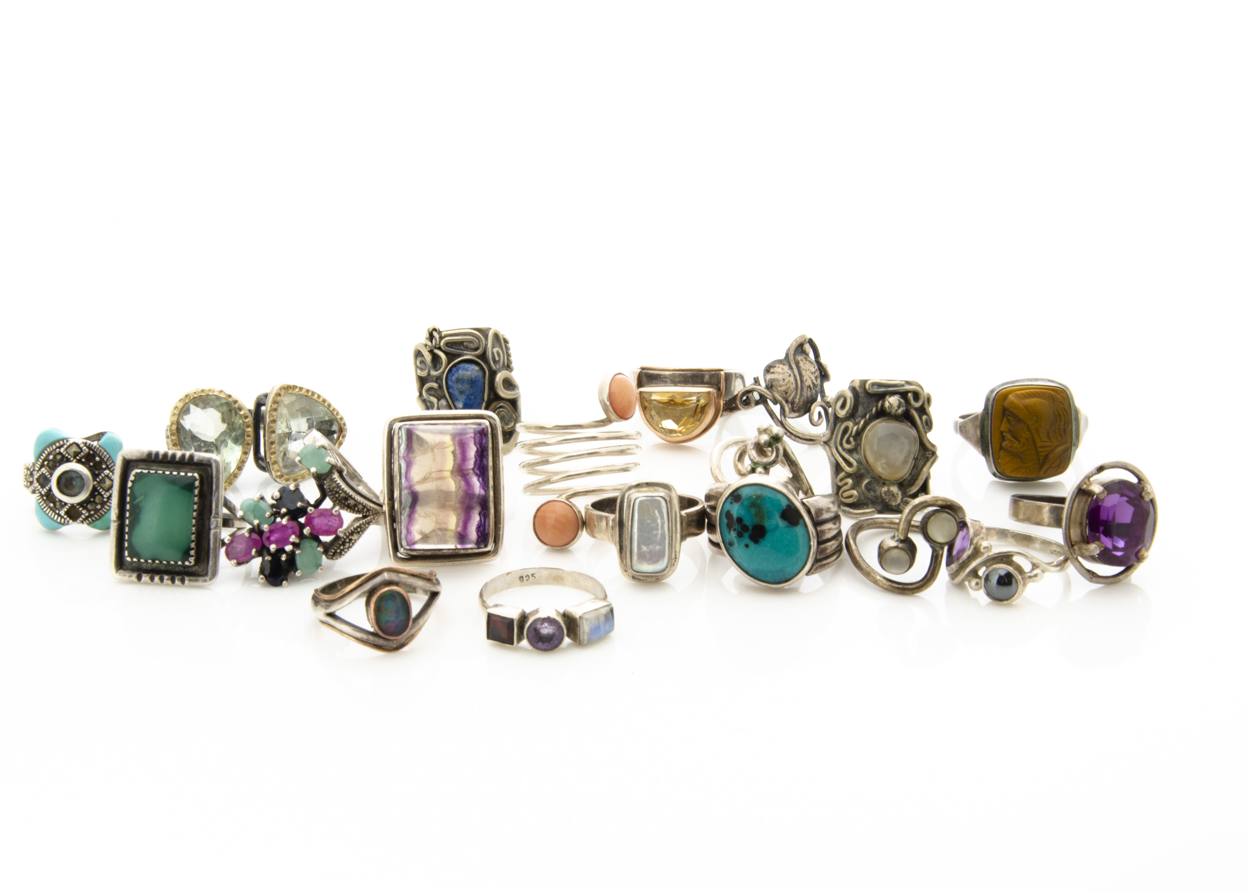 A collection of silver gem set dress rings, including tiger's eye, citrine, turquoise, synthetic