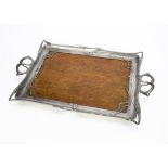 A continental Art Nouveau twin handled pewter and pine tray, the wooden base surrounded by a frame