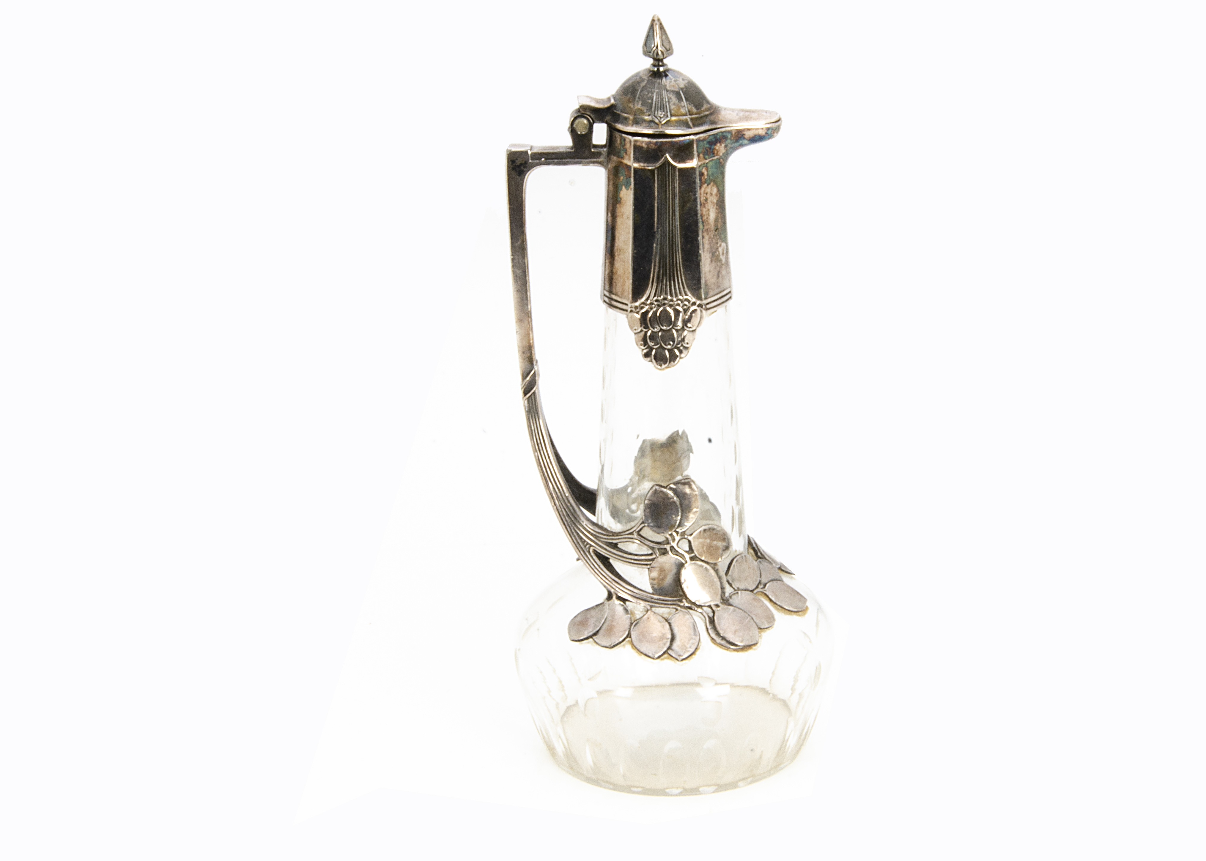 A WMF silver plated on pewter and cut glass claret jug, the colourless glass base with oval roundels