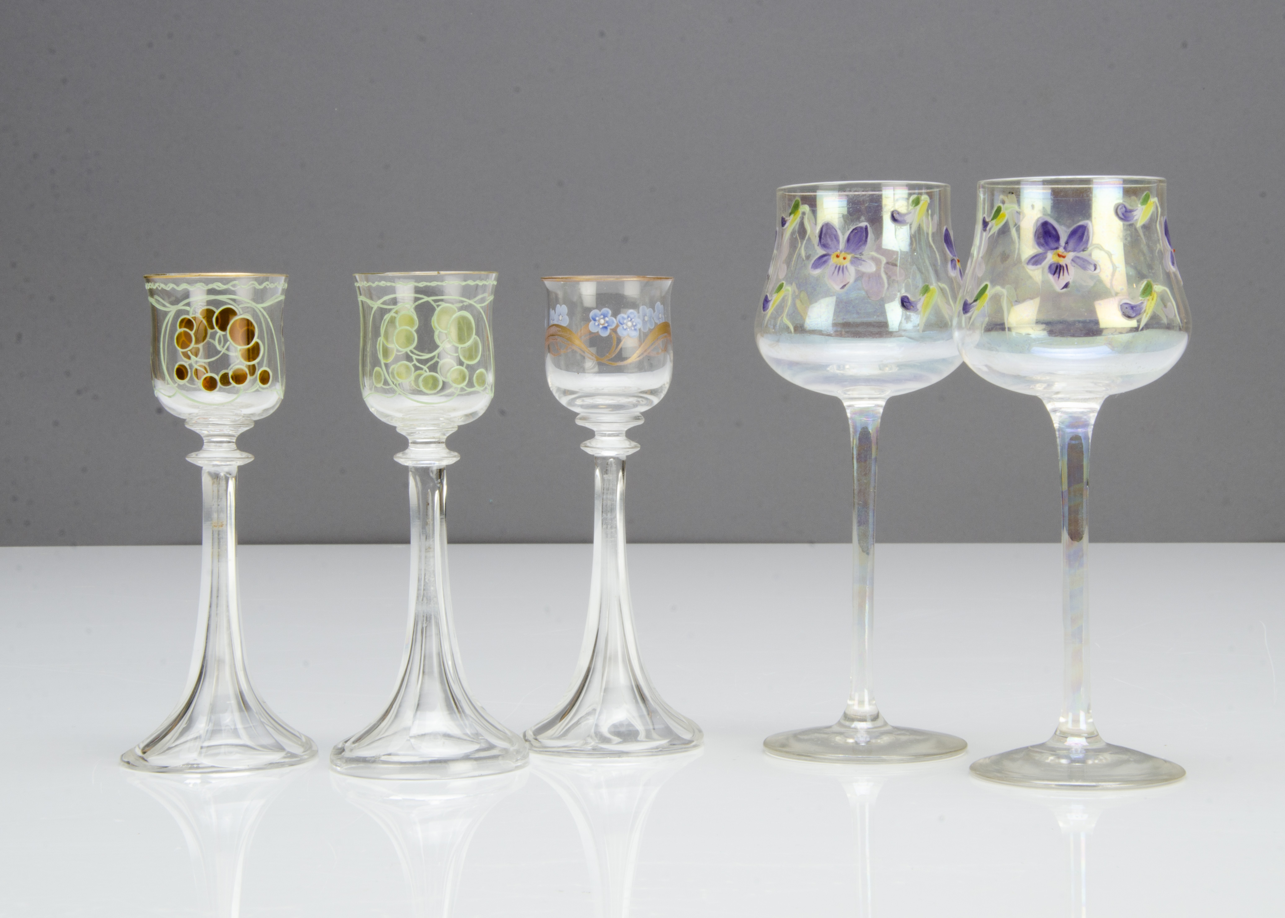A pair of German Art Nouveau liquor glasses, in the Meyr's Neff style with green and amber floral