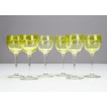 A set of six continental early 20th Century green bowled wine glasses, with wheel engraved arched