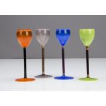A set of four continental harlequin coloured Vaseline liquor glasses, in orange, green, blue and