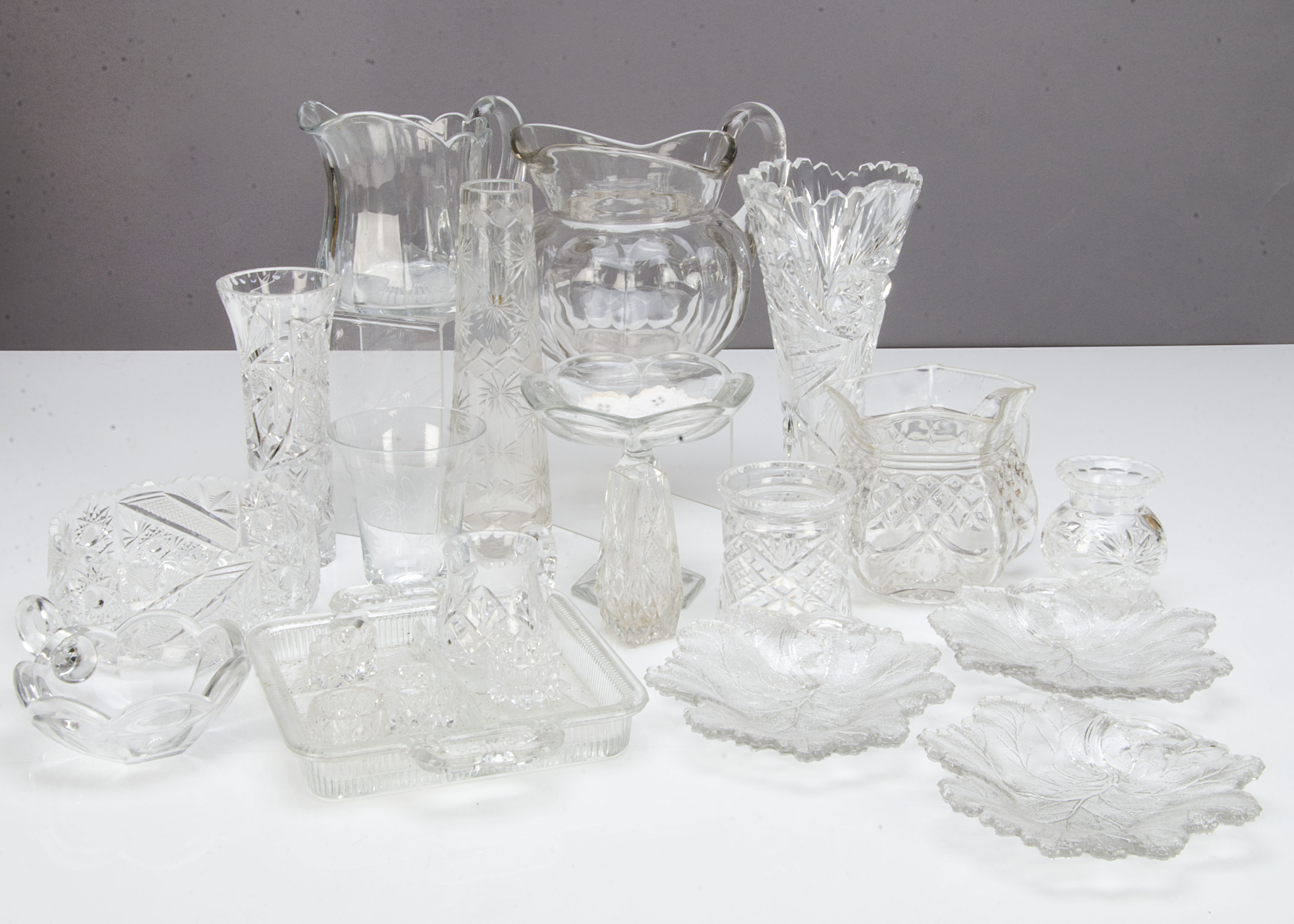 A collection of cut glassware, including a continental tapered cut glass flower a vase on a circular