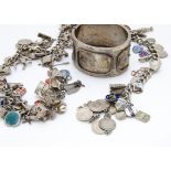 Three silver charm bracelets, with various charms and silver and enamel shield badges, together with