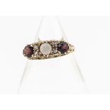 A 9ct gold Victorian style opal, topaz and garnet dress ring, the central white precious opal in