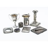 Two Art Deco period silver cigarette cases, together with a small silver trophy cup, a silver