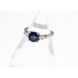 A three stone 18ct white gold sapphire and diamond ring, circular mixed cut in four claw setting