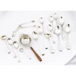 A group of silver spoons and more, including a silver tea strainer with wooden handle by Adie