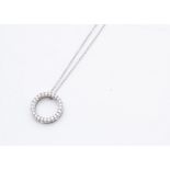 An 18ct white gold diamond set circular pendant, the brilliant cuts in claw setting marked 750 on