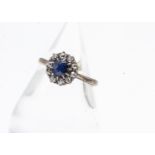 A sapphire and diamond cluster ring, the circular cut claw set sapphire surrounded by old cut