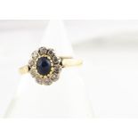 A continental sapphire and diamond cluster ring, all in yellow metal marked 750, with cabochon