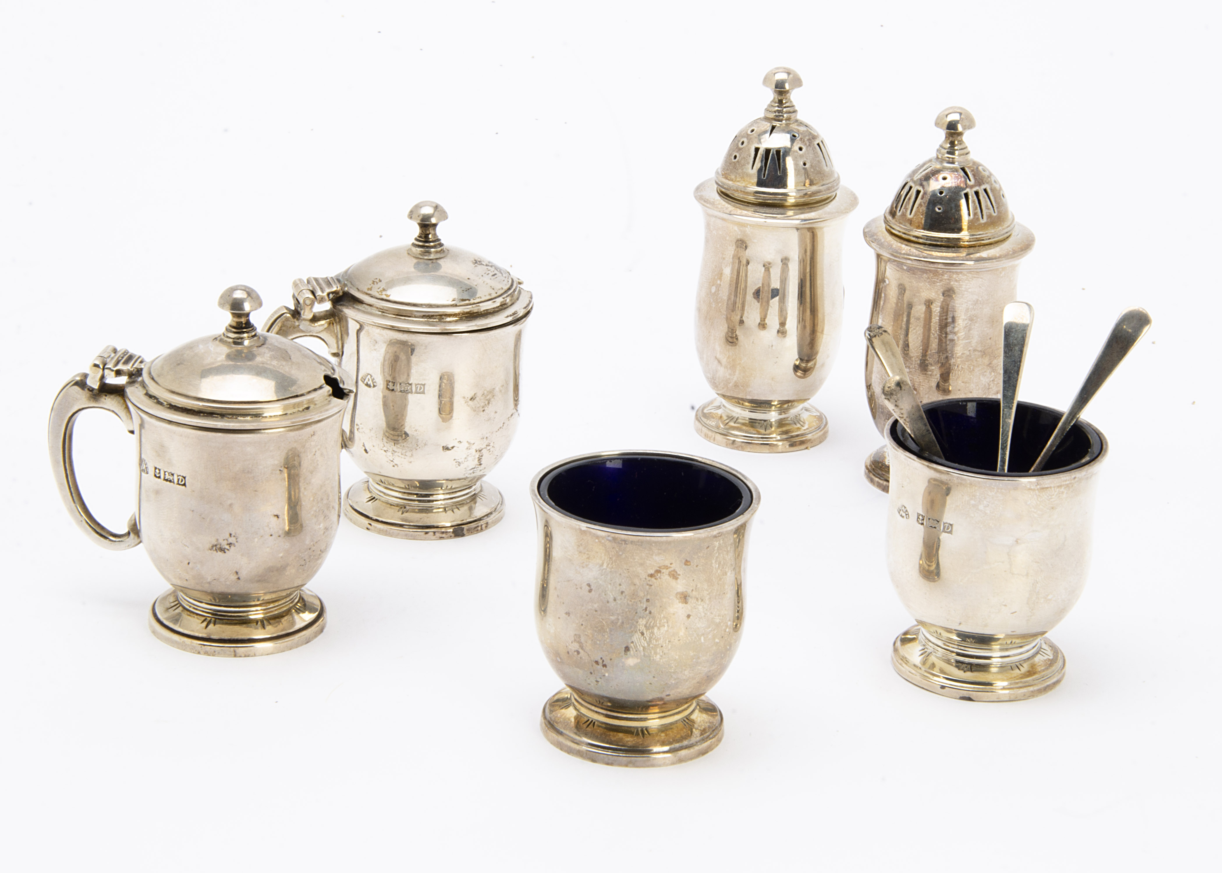 A late 1950s silver cruet set by Adie Bros, comprising a pair of salts, peppers and mustards, with