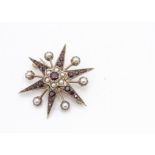 A gold , garnet and pearl star brooch, the six point star with garnet points centred with a