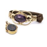 A Victorian amethyst, pinchbeck and human hair bracelet, the large oval amethyst in collared setting