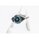 An Art Deco white metal zircon dress ring, the circular cut blue zircon in a four claw clamp setting