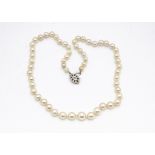 A cultured string of knotted pearls, the graduated pearls united with a white gold and diamond