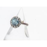 A zircon and diamond cluster dress ring, the circular mixed cut blue zircon in a four claw setting