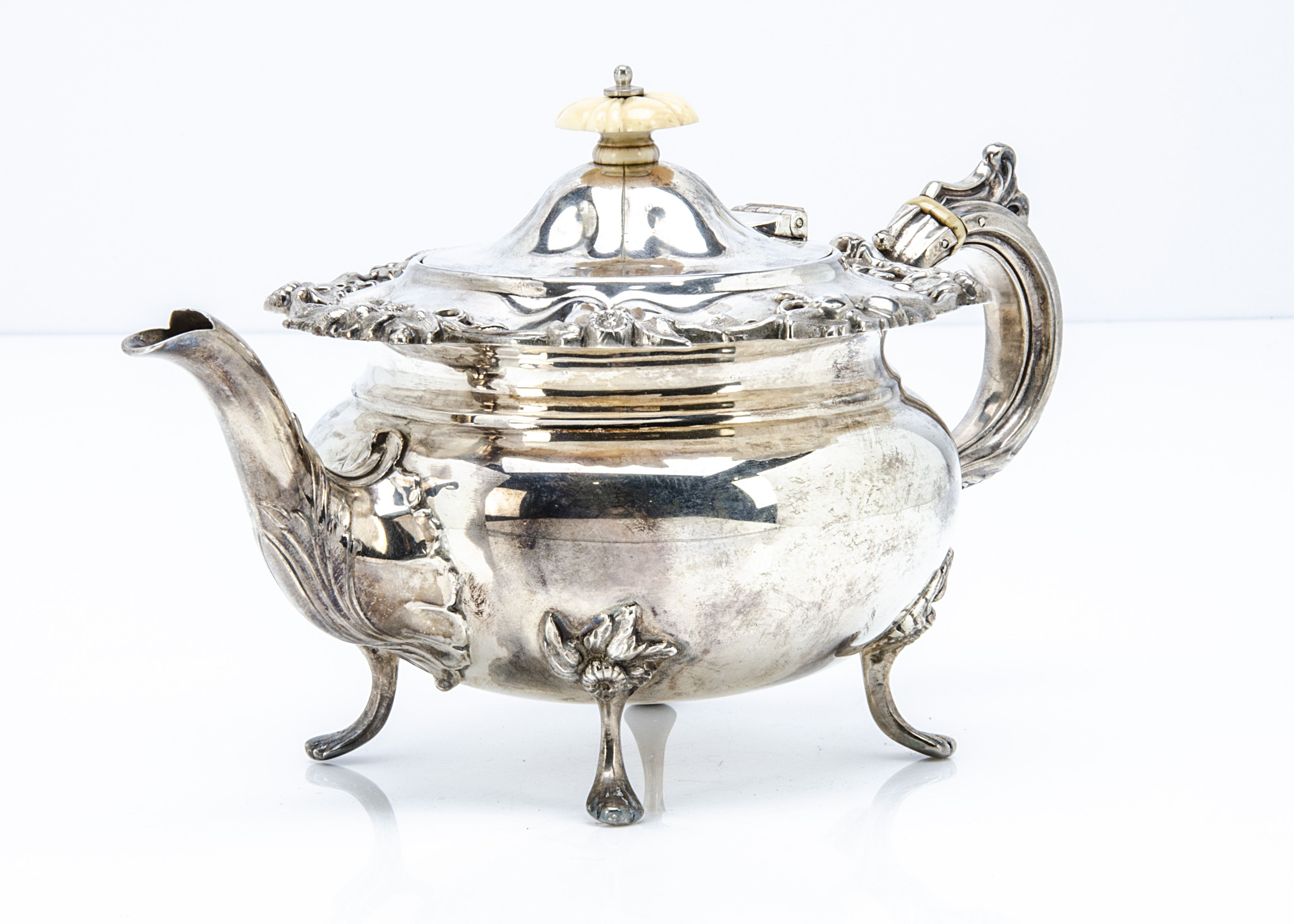 A late Victorian silver bachelors teapot by J & T, floral design to upper rim and on four