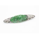 An Art Deco diamond, jade, platinum and 18ct gold brooch, the central Chinese carved green jade oval