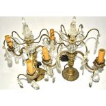 A pair of gilt metal and prism glass table lights, of three branched form, with faceted glass drops,