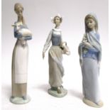 Three Lladro porcelain figures, girl and lamb, girl with basket of flowers and girl with lilies,