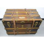 An early 20th Century wooden bound travel trunk, with lift out tray to the interior and lined with