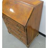 An antique walnut bureau with crossbanding and herring bone inlay, fitted stepped interior, four