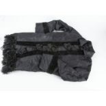 A child's mourning dress of black silk taffeta, trimmed with black velvet ribbon, large cone