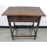 An antique oak side table, three plank top with moulded edge, frieze drawer with brass drop handles,