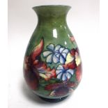 A large Moorcroft Pottery vase in the 'Orchid and Spring Flowers Pattern', on a green ground with