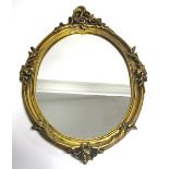 A giltwood framed oval mirror in the rococo style, length 66cm
