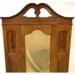 An Edwardian mahogany wardrobe, pierced cornice above single door with mirror with moulded flowers