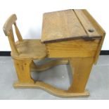 A late 19th Century oak childs school desk and chair, the desk having an inkwell hole and pencil