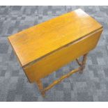 A 1920s honey oak drop flap table, moulded top with rounded corners, turned supports united by