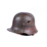 A WWI German M16 helmet, with faded painted camo design, stamped BF62 to inside, remanence of hand