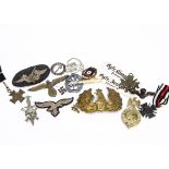 A collection of German badges and medals, including SS skull cap badge, a Prussian helmet badge, a