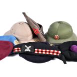 A collection of British and overseas hats, including two Pith helmets, Glengarrys and side caps,