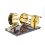 A vintage brass fishing reel mounted display, comprising of two unnamed reels, including a 4½"