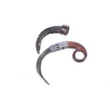 An Indonesian Karambit Claw knife, with hole finger grip, leading to a curved body and blade in