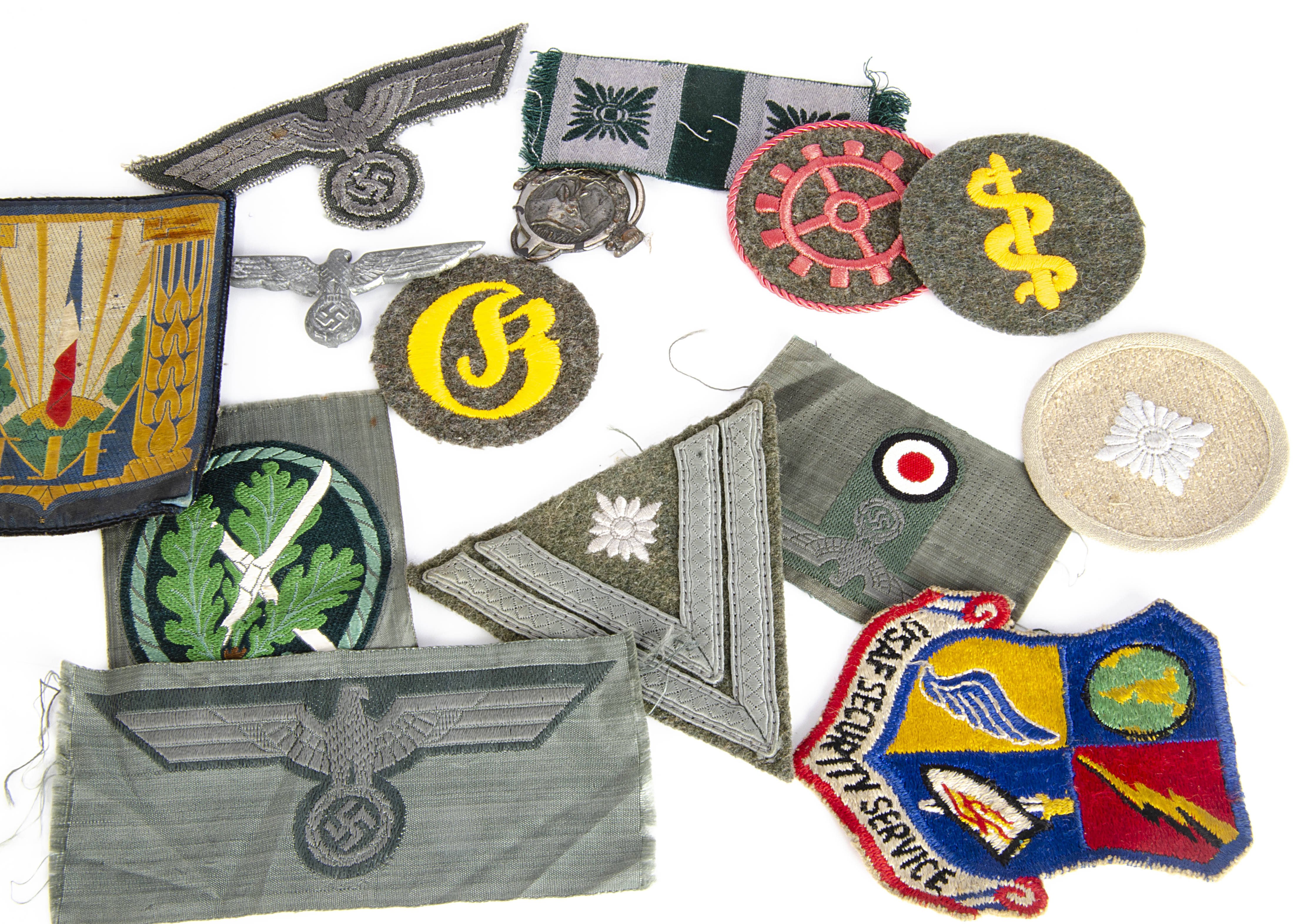 A small collection of German and overseas cloth badges, together with a metal German eagle and a