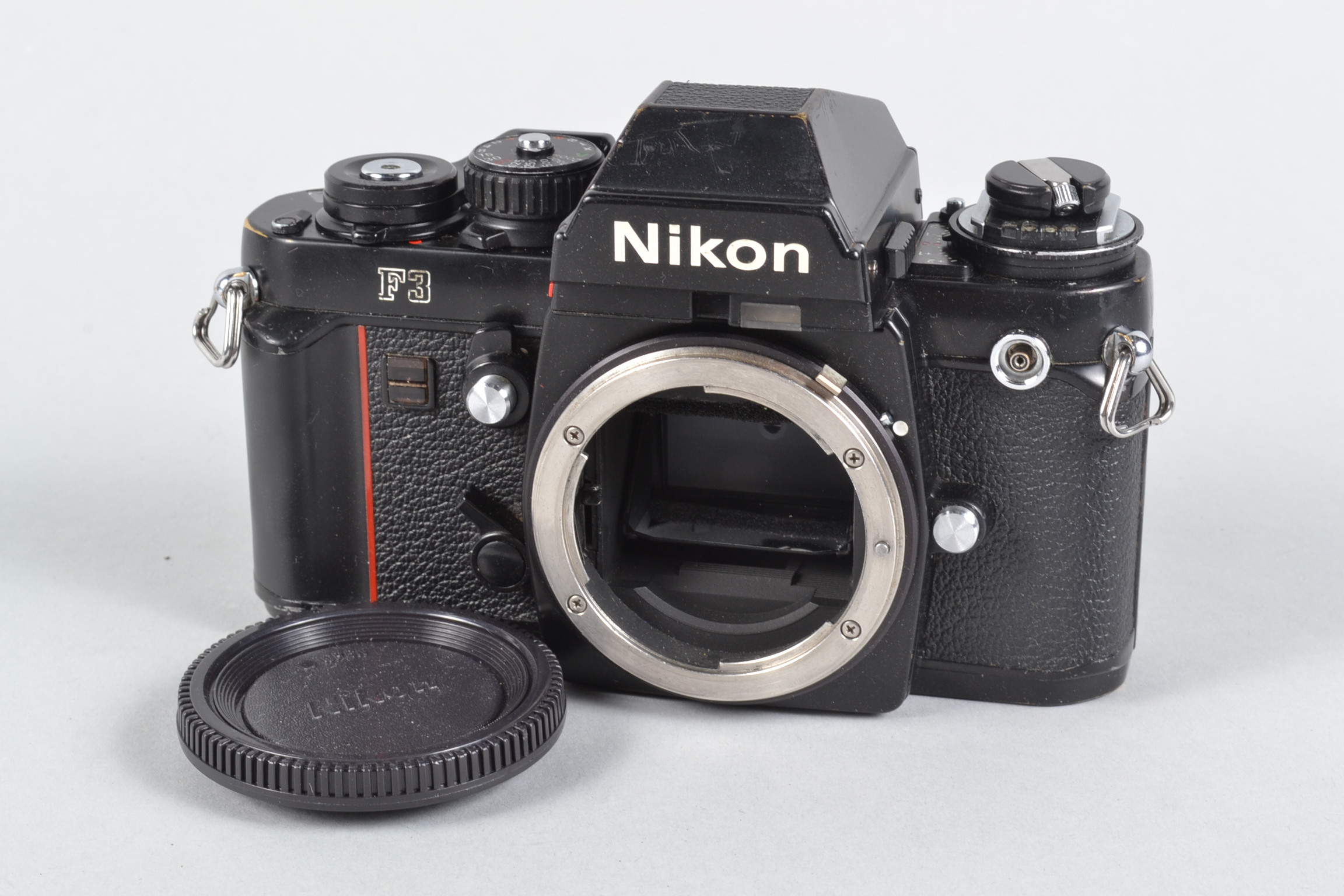 A Nikon F3 SLR Body, serial no 1 667 301, DE-2 eye level viewfinder, body F, brassing to edges,