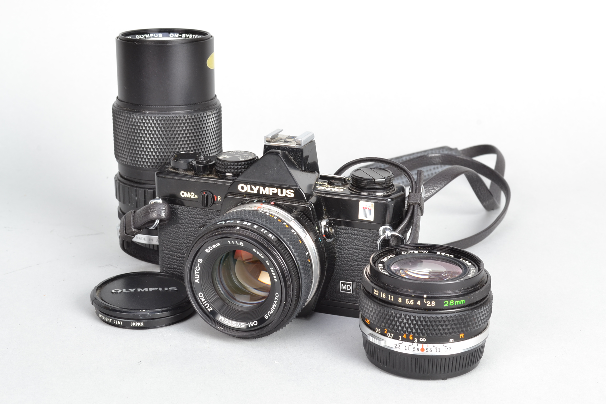 An Olympus OM2n Camera, black, serial no 1059132, body G, light scratches, light wear around strap