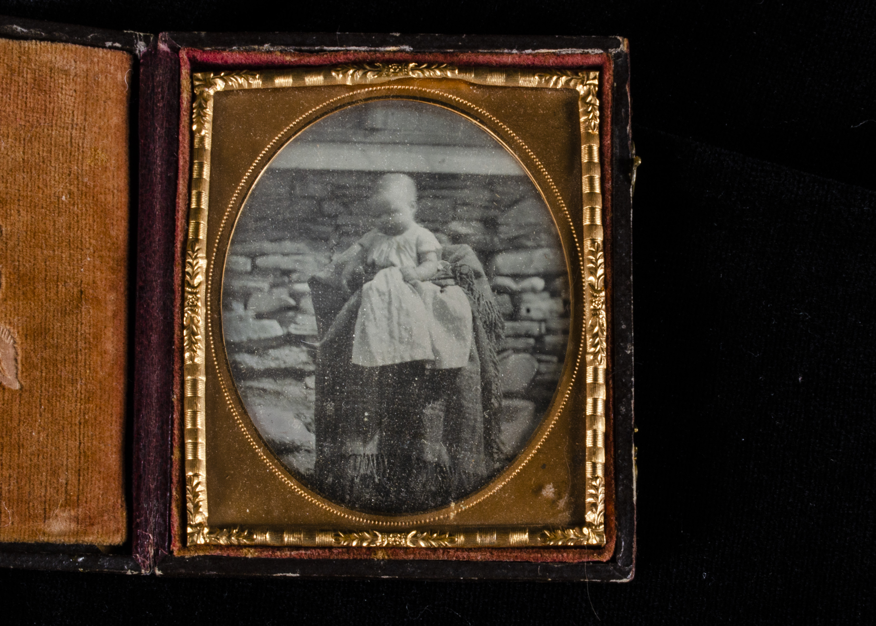 A mid-19th Century cased Sixth-Plate Daguerreotype of a Baby, cradled outside in chair covered