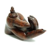 An earthenware oil lamp taking the form of a partially open hand with outstretched finger, the