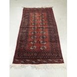 Old Middle Eastern Rug, a bordered geometric patterned red ground example with eighteen oval
