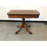 A Victorian rosewood games table, swivel folding top, 90cm wide, on pedestal base with four supports